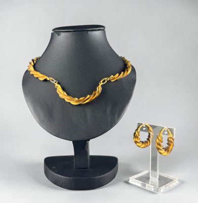a necklace and earring set on display on a stand