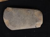 a rock that is sitting on a table next to a knife