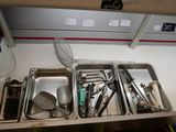 several trays of utensils are lined up on a shelf