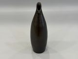 a black vase that is sitting on a white surface