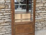 a small display case with a glass door in front of a stone wall