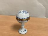 un petit œuf blanc et bleu posé sur une table en bois