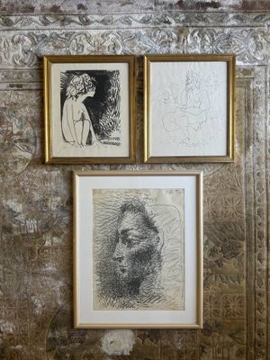 three framed drawings of a man and a woman on a wall