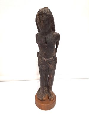 l'image d'une statue de femme debout sur un socle en bois