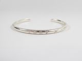 a close up of a silver cuff bracelet with diamonds on it