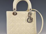 un sac à main blanc muni d'une poignée en métal et d'une chaîne