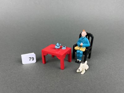 a miniature figurine of a man sitting at a table with a cat