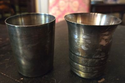 deux tasses en métal posées l'une à côté de l'autre sur une table