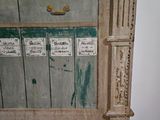 an old wooden cabinet with a lot of labels on it