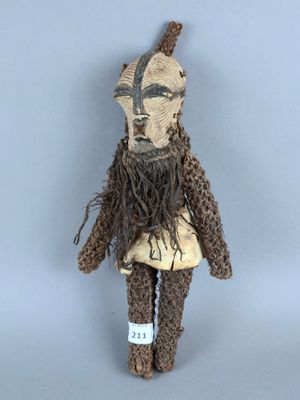 une petite peluche qui porte un chapeau et une barbe