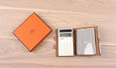 une boîte orange contenant une calculatrice et une autre calculatrice à l'intérieur