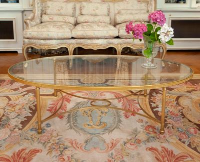 a glass table with flowers on it in a living room