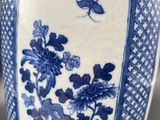 a blue and white vase sitting on a table with a plant in it