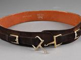 brown leather belt with two metal buckles on a gray surface