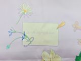 a piece of paper with flowers on it next to a piece of paper with a note attached to it