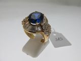 une image représentant une bague en or sertie d'une pierre bleue entourée de diamants