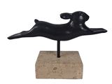 sculpture of a black dog on a stone base on a white background