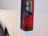 the back end of a white van parked on the side of the road