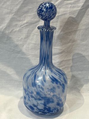 a blue and white glass bottle on a white table