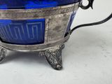 a blue glass bowl with a silver handle on a stand