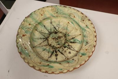 a white plate with a green and brown design on it