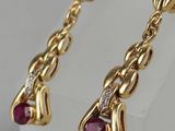 a pair of gold and ruby earrings with diamonds