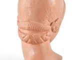 a close up of a clay head on a white surface