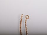 a close up of a pair of gold chains on a white background