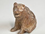 a small statue of a bear sitting next to a smaller statue of a bear