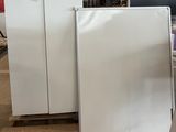 deux réfrigérateurs blancs posés sur une palette dans un entrepôt