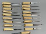six knives are lined up in a row on a gray surface