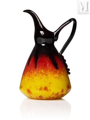 un vase noir et jaune muni d'une anse, posé sur une surface blanche