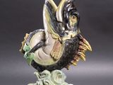 figurine représentant un oiseau noir et blanc sur un socle vert