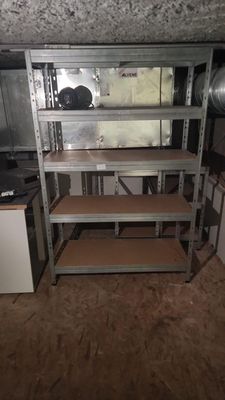 a kitchen with a stove and shelves in it