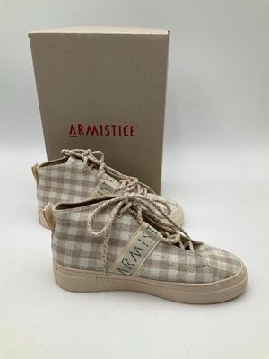 une paire de chaussures avec une boîte posée sur une surface blanche