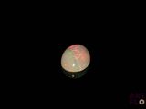 an image of a white and red fire opal in the dark