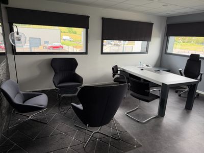 trois chaises et une table dans une pièce dotée de deux fenêtres