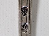 a silver spoon with a design on it sitting on a table