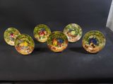 six small bowls with flowers painted on them sitting on a black chair