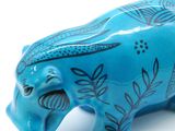 a blue elephant figurine on a white surface