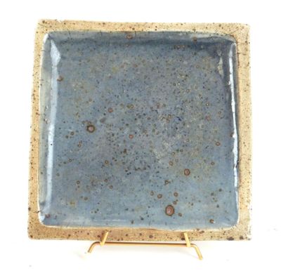 a blue plate with a gold stand on a white background