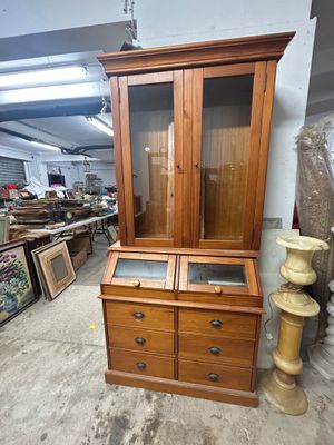 une armoire en bois avec deux tiroirs et une porte vitrée