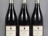 three bottles of wine are lined up on a table