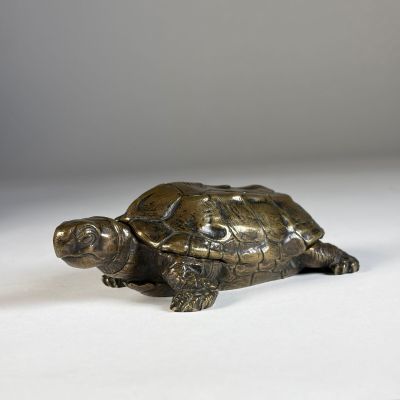 figurine en bronze représentant une tortue sur un fond blanc