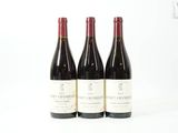 trois bouteilles de vin sont alignées sur une surface blanche