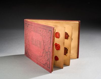 un livre rouge orné d'un cachet de cire, posé sur une table
