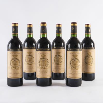 six bouteilles de vin sont alignées sur une surface blanche