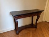 une table en bois avec un plateau noir dans une pièce