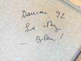 une inscription écrite à la main sur le mur d'une salle de bains, accompagnée d'une image représentant des toilettes et un rouleau de papier toilette