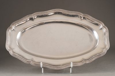 an oval silver platter on a stand on a grey background